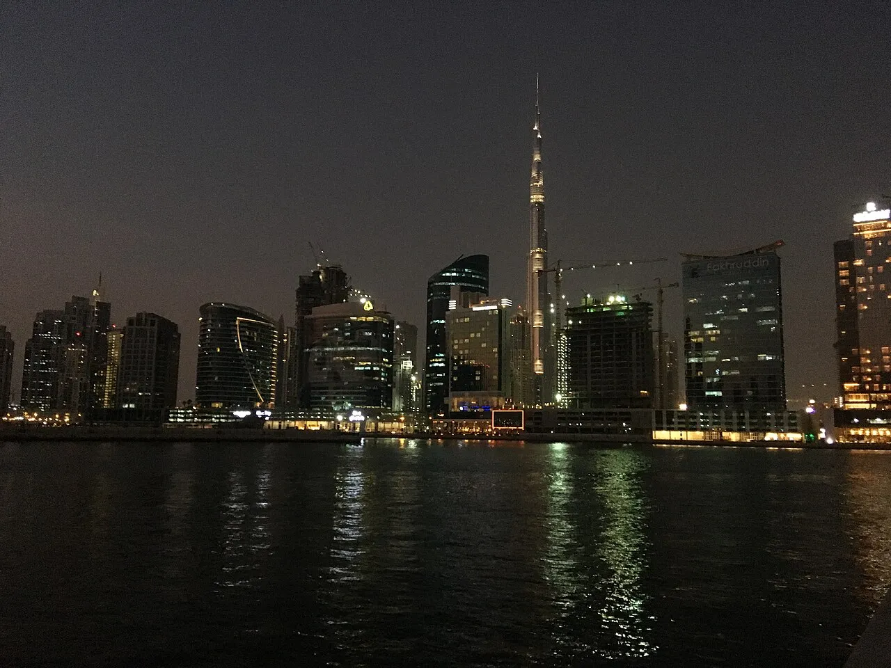 Dubai towers reflected in the water at night